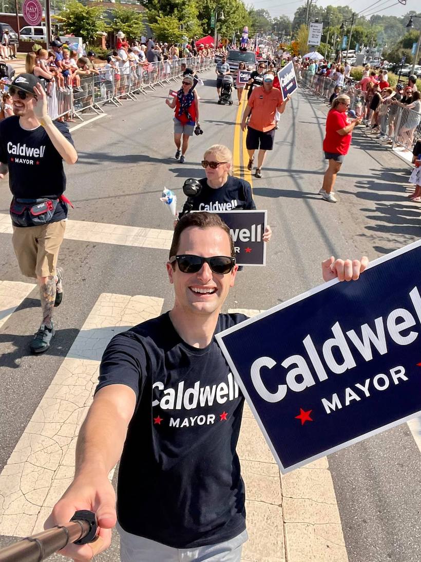 Michael Caldwell and volunteers march in the Woodstock parade with Caldwell for Mayor signs